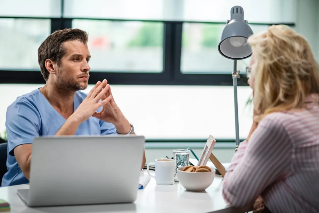 Persona conversando con un profesional de la salud mental en un ambiente terapéutico respetuoso.